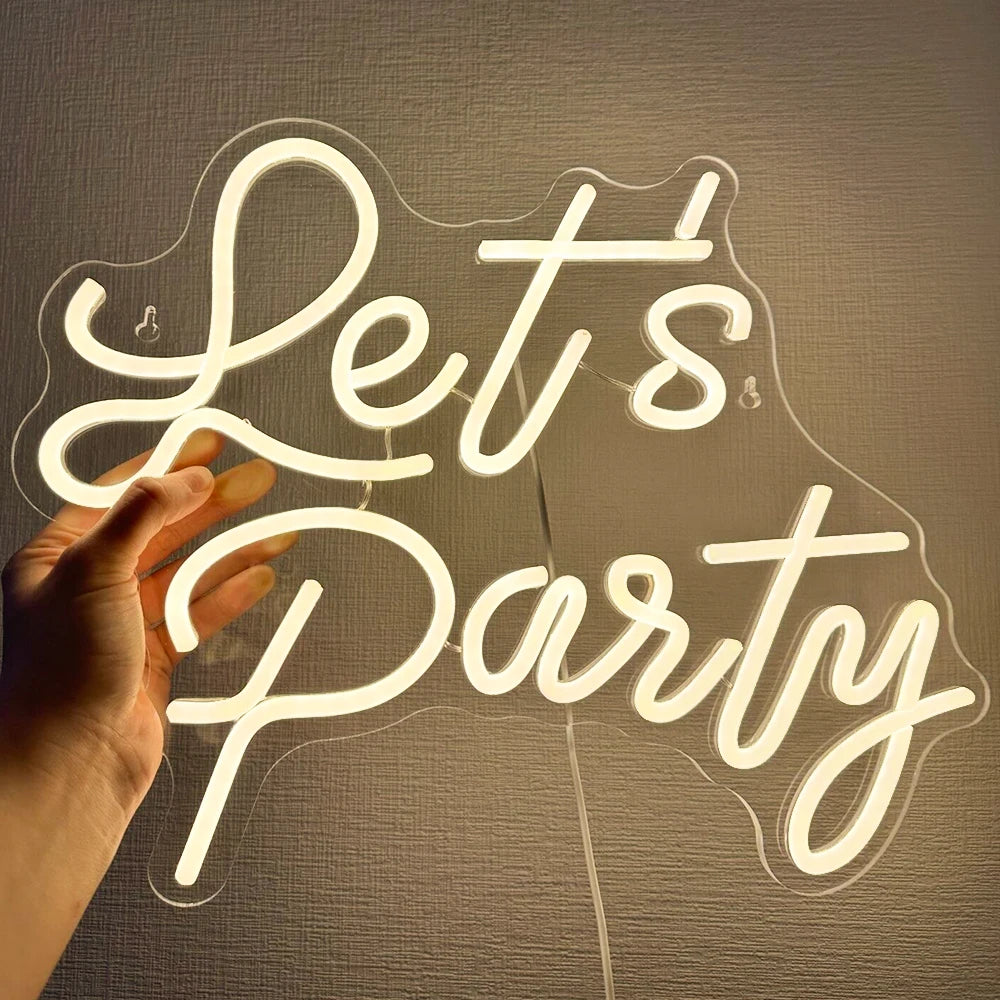 Un panneau néon LED vibrant affichant les mots « Let's Party » en lettres cursives et audacieuses.