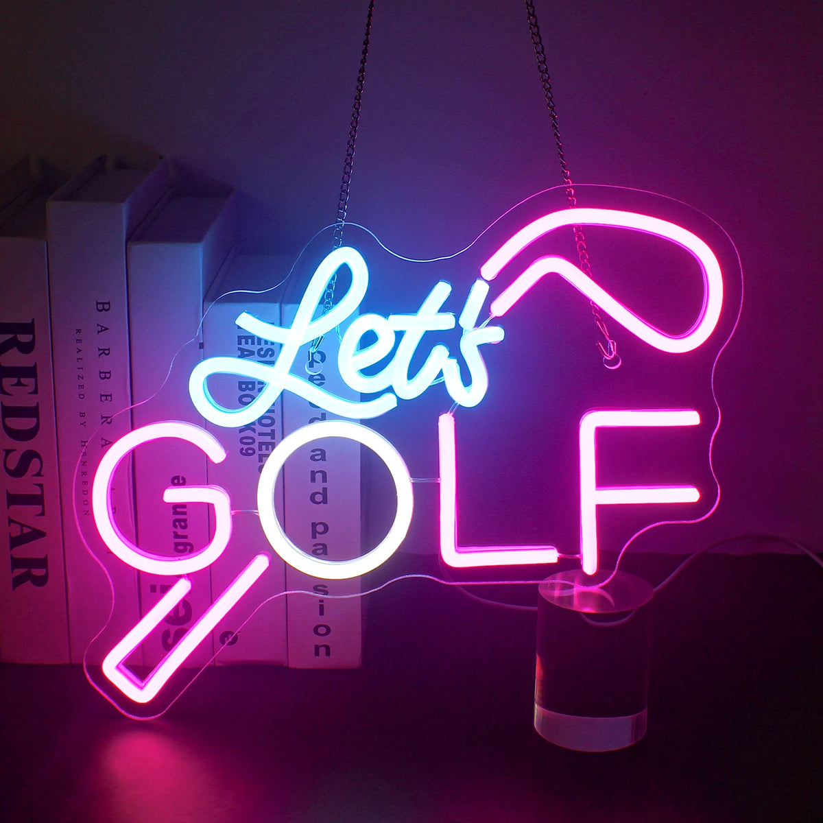 Un vibrante letrero de neón LED que muestra las palabras "Let's Golf" en colores verde y blanco brillantes.