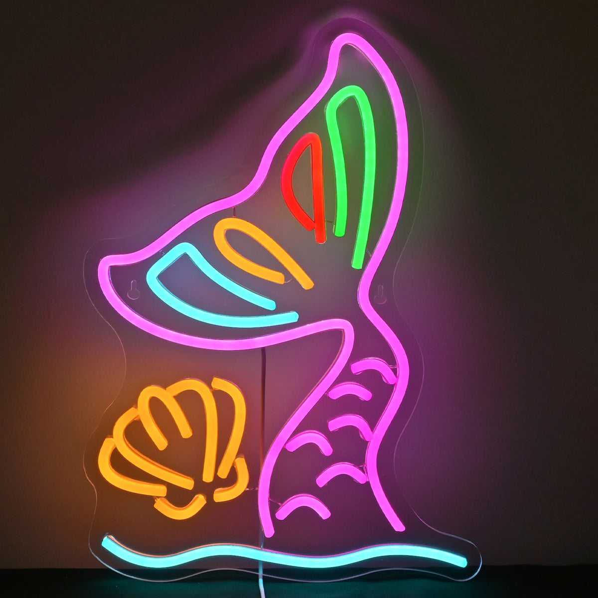 A képen élénk LED-es neonreklám látható sellőfark formájában.