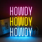 Živahni, ručno izrađeni LED neonski znak koji prikazuje riječ "Howdy" razigranim, kurzivnim fontom.