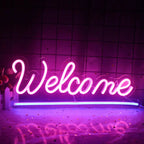 Un panou luminos cu neon LED „Bun venit” afișat pe un perete alb simplu.