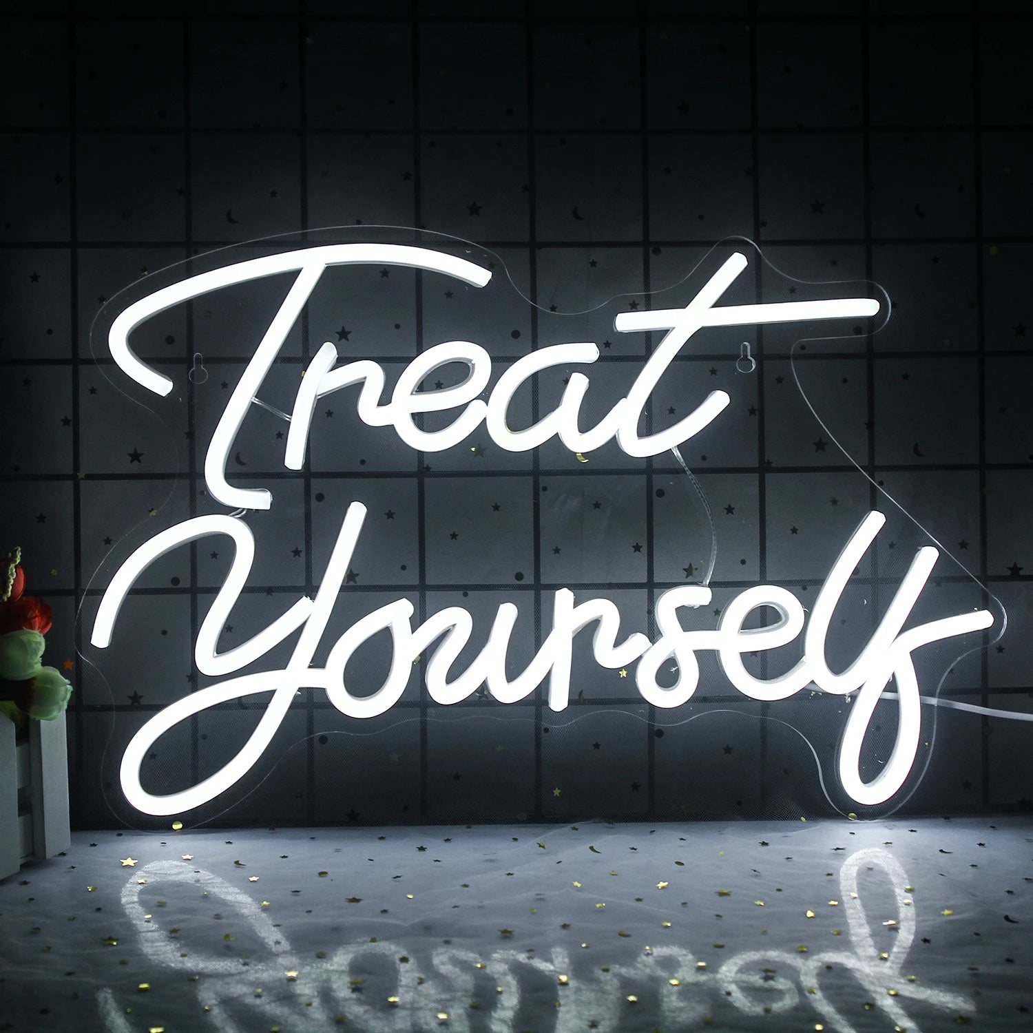 The image shows a vibrant LED neon sign featuring the phrase "Treat Yourself" in a playful cursive font.