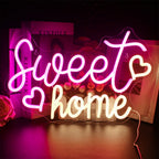 Billedet har et levende, håndlavet LED-neonskilt, der viser ordene "Sweet Home" i et stilfuldt, kursivt skrift.