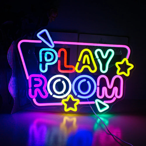 Imaginea prezintă un panou cu neon LED vibrant pe care scrie „Camera de joacă” în culori strălucitoare și jucăușe.