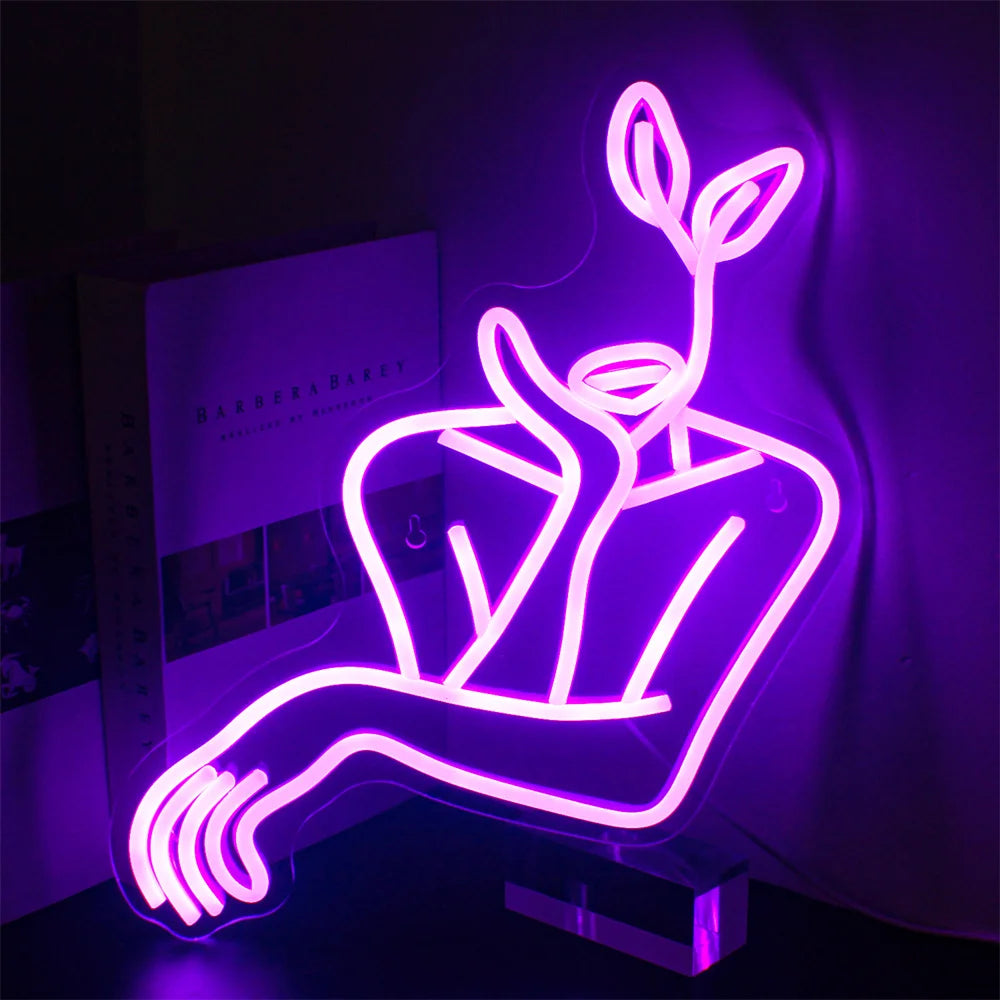 Na obrázku je stylový LED neonový nápis zobrazující minimalistickou liniovou kresbu ženské tváře.