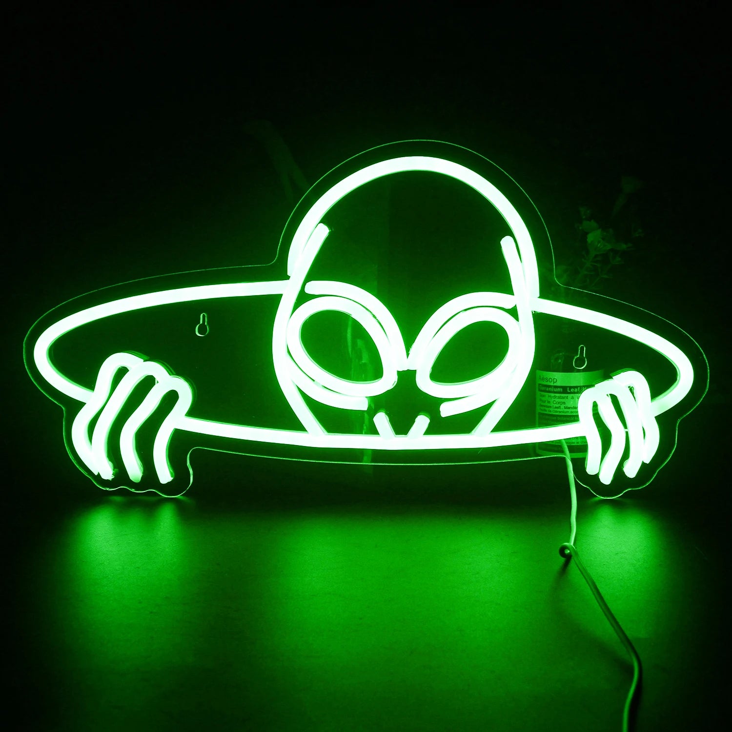 Un'insegna al neon a LED vibrante a forma di testa di alieno, con grandi occhi a mandorla.