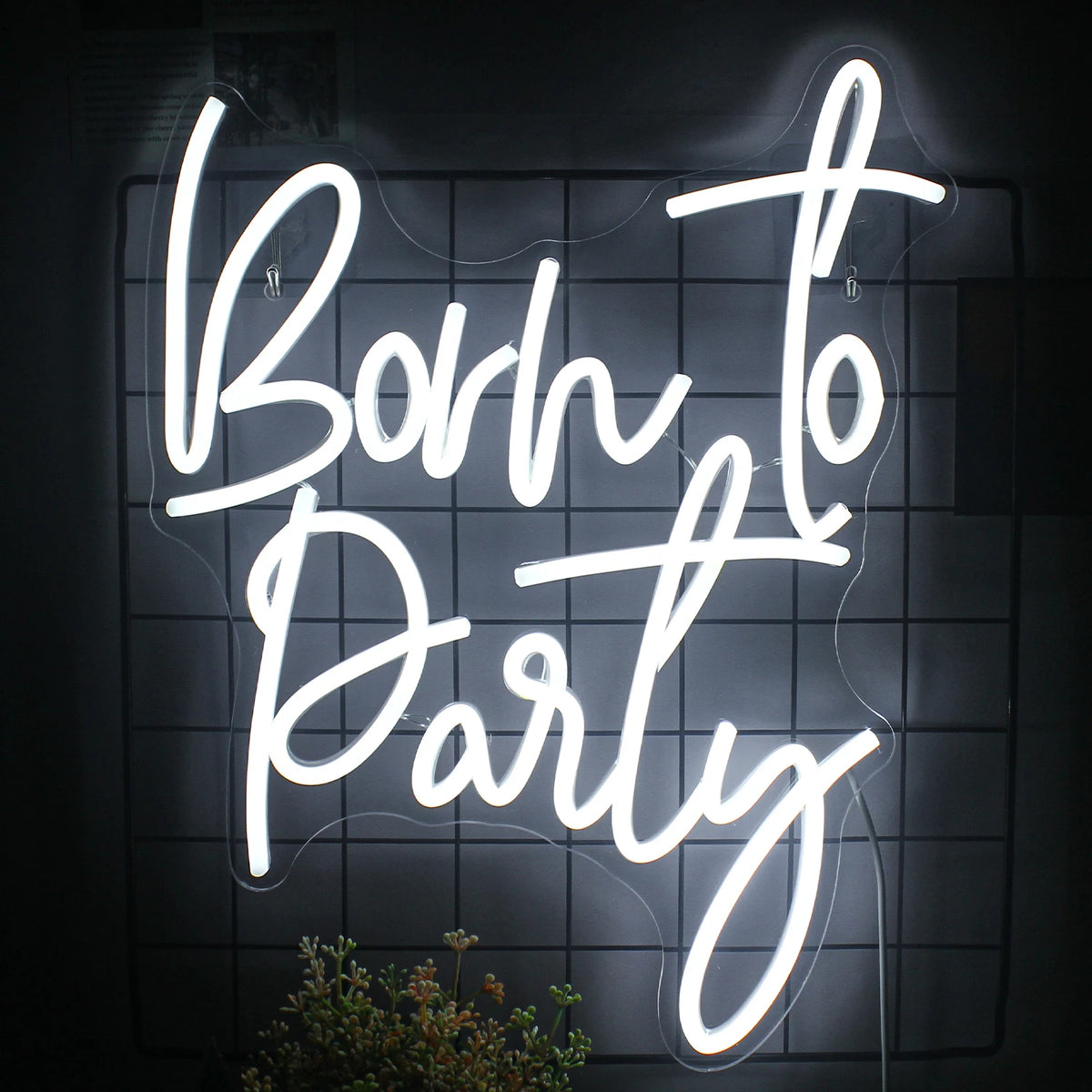 A képen élénk "Born to Party" LED fényreklám látható.