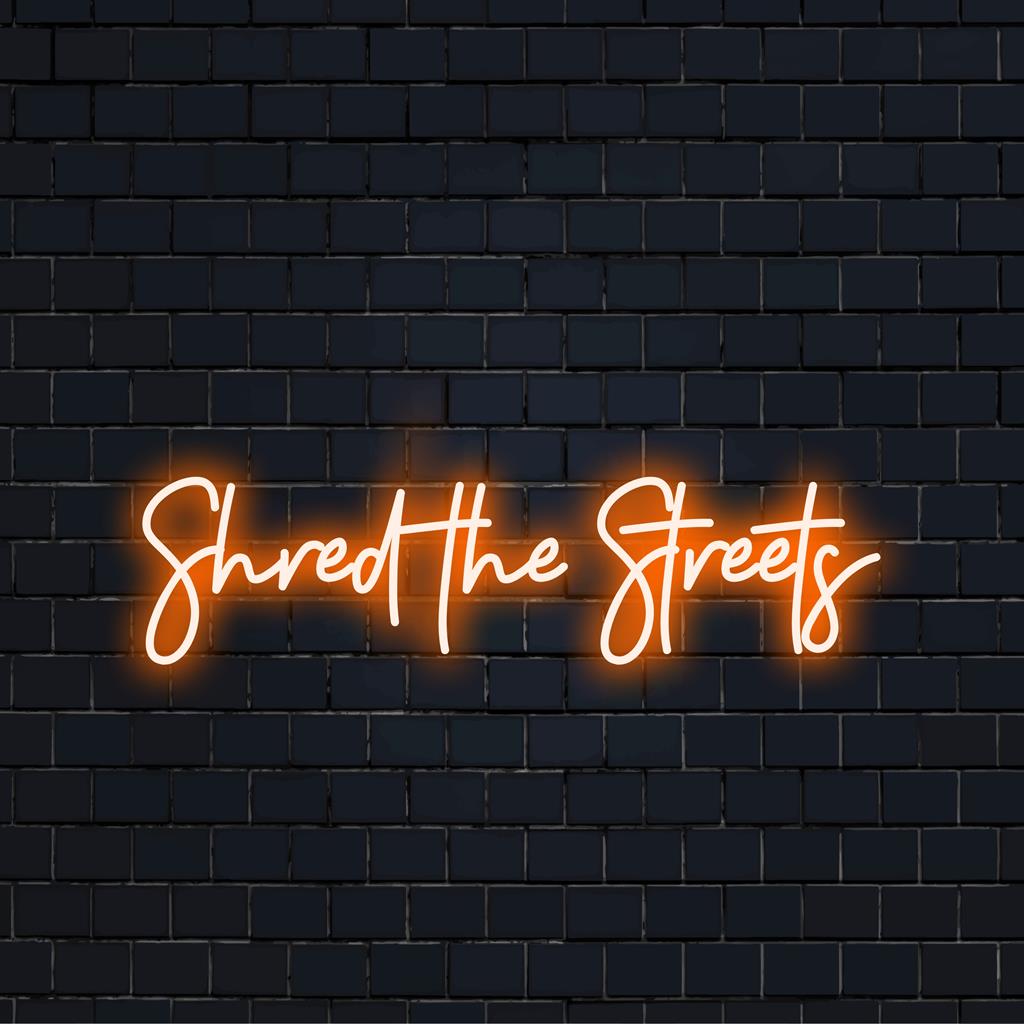 Custom LED neon sign spelling out Shred The Streets in vibrant colors. Perfect neon decor for enhancing any modern space.