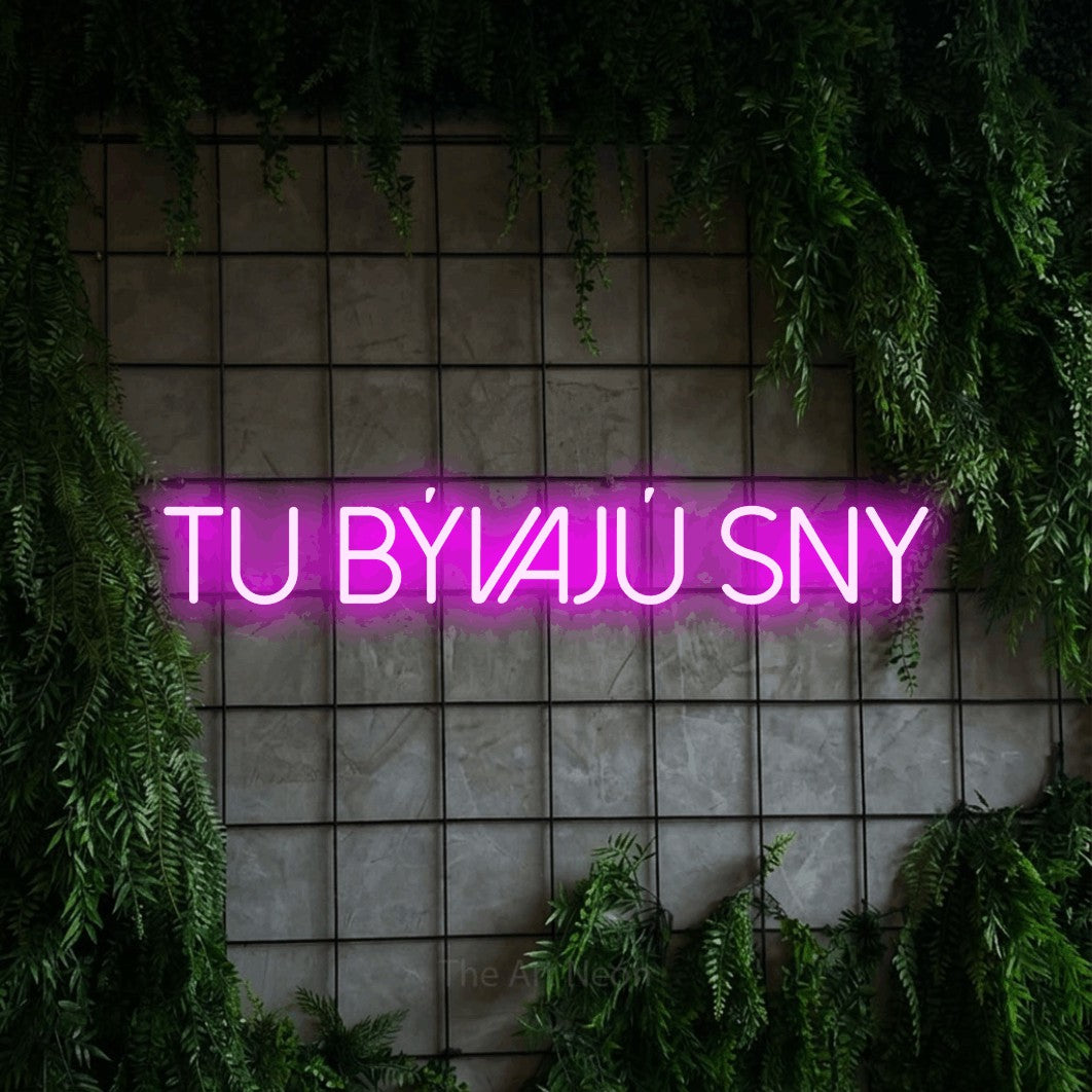 LED neon sign reading “TU BÝVAJÚ SNY”, arranged in a single line.