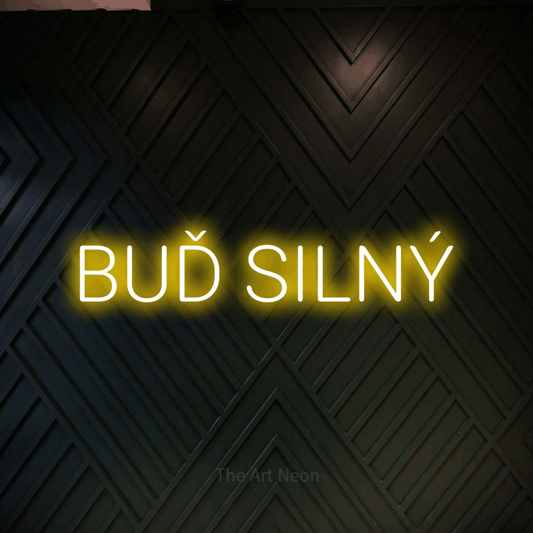 LED neon sign reading “BUĎ SILNÝ”, arranged in a single line.