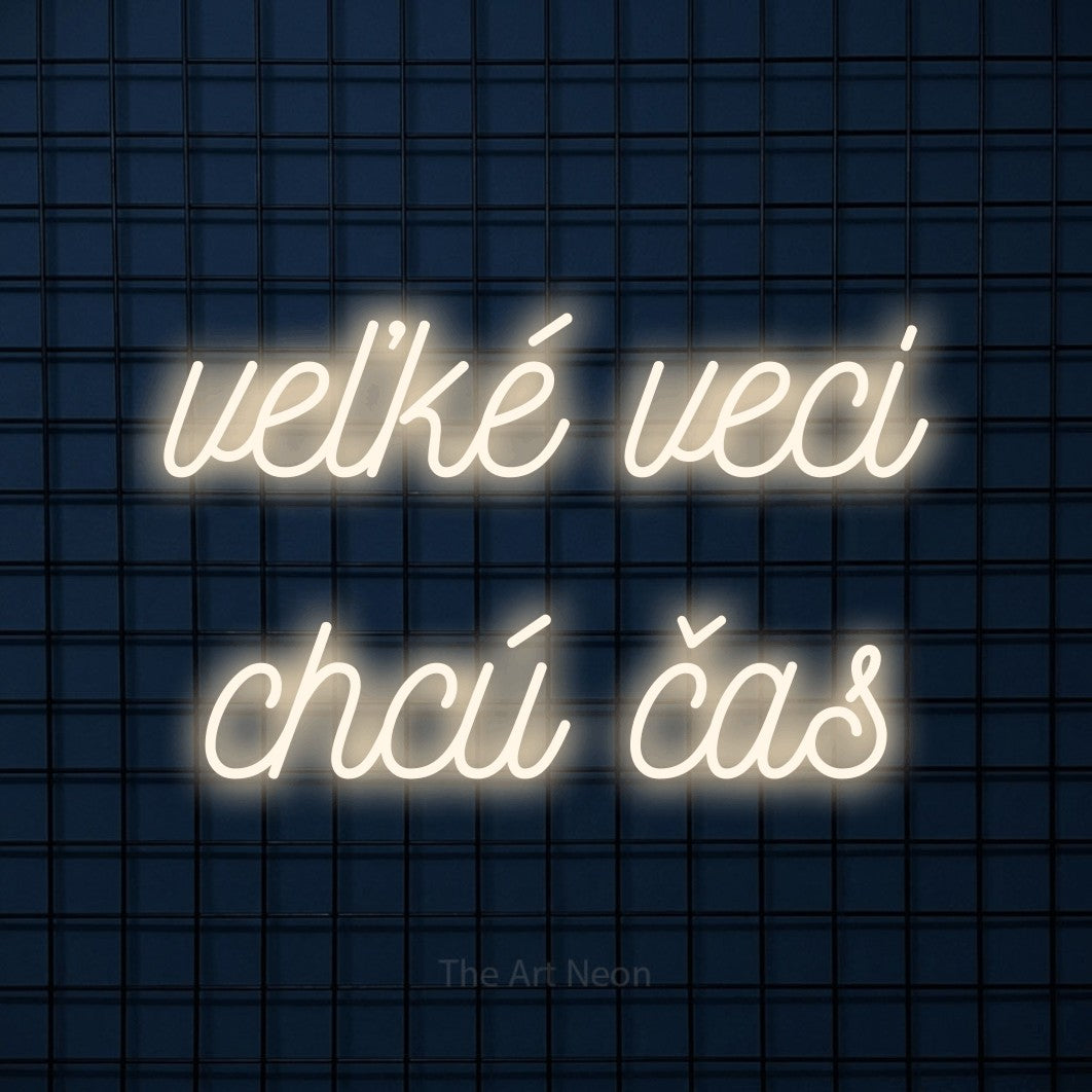LED neon sign reading “veľké veci chcú čas”, arranged in two lines.