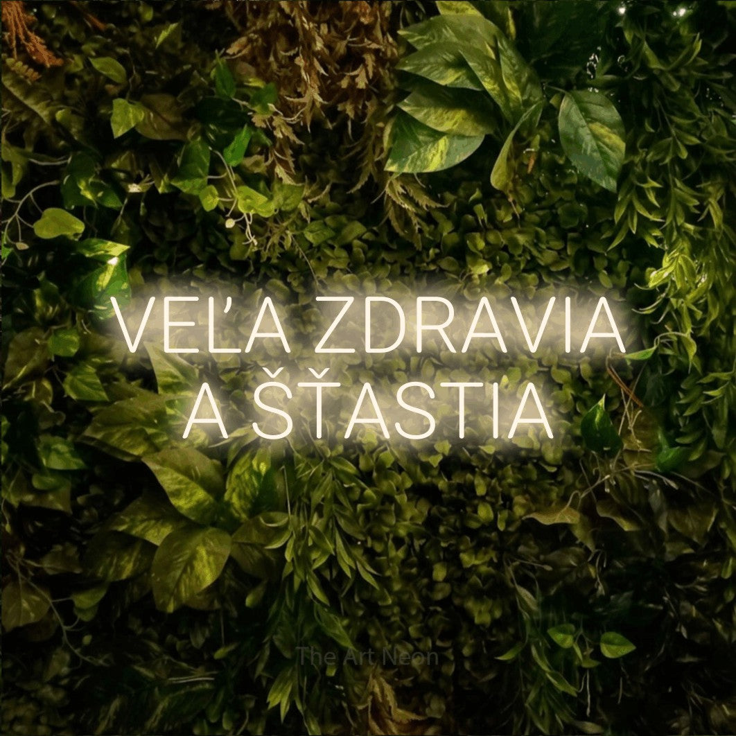 LED neon sign reading “VEĽA ZDRAVIA A ŠŤASTIA”, arranged in two lines.