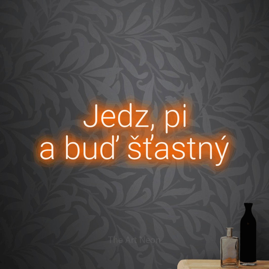 LED neon sign reading “Jedz, pi a buď šťastný”, arranged in two lines.