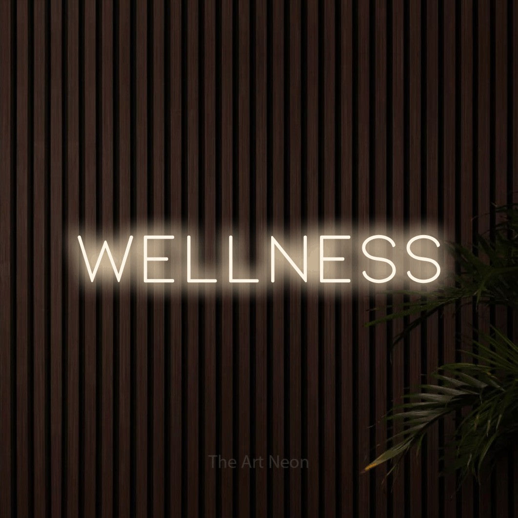 LED neon sign reading “wellness”, arranged in a single line.