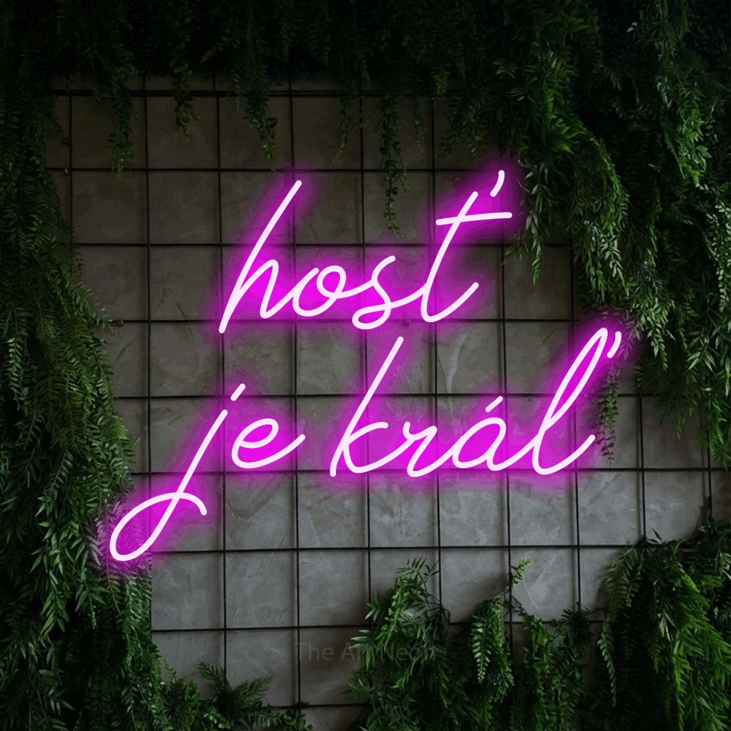 LED neon sign reading “hosť je kráľ”, arranged in two lines.