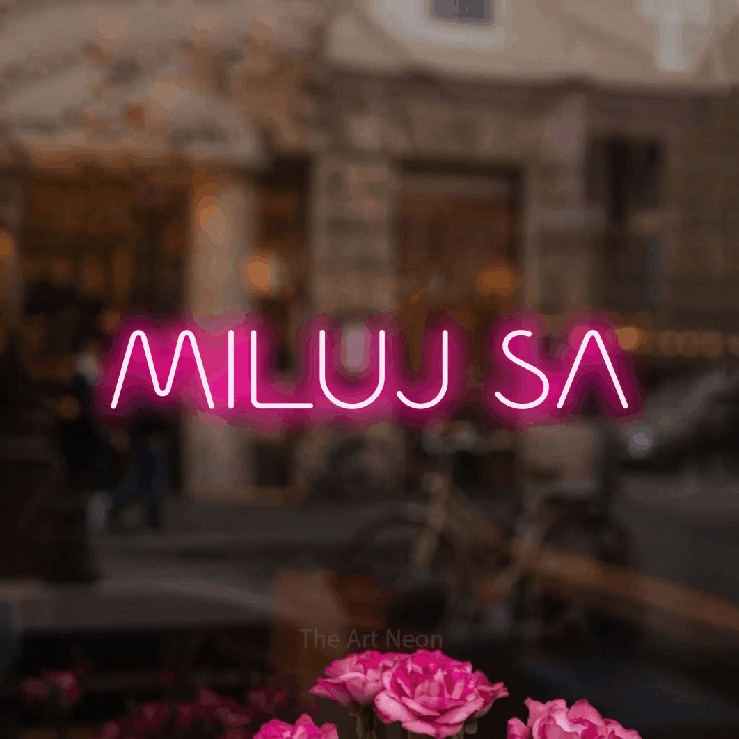 LED neon sign reading “MILUJ SA”, arranged in a single line.
