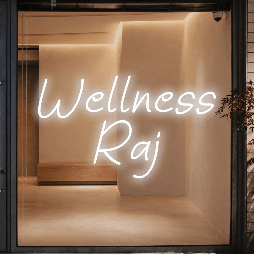 LED neon sign reading “Wellness Raj”, arranged in two lines.