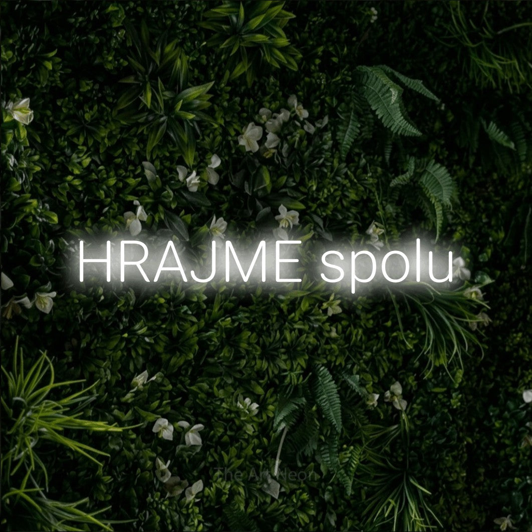 LED neon sign reading “HRAJME spolu”, arranged in a single line.