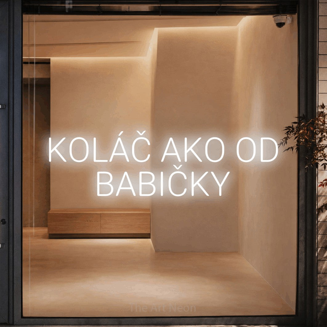 LED neon sign reading “KOLÁČ AKO OD BABIČKY”, arranged in two lines.