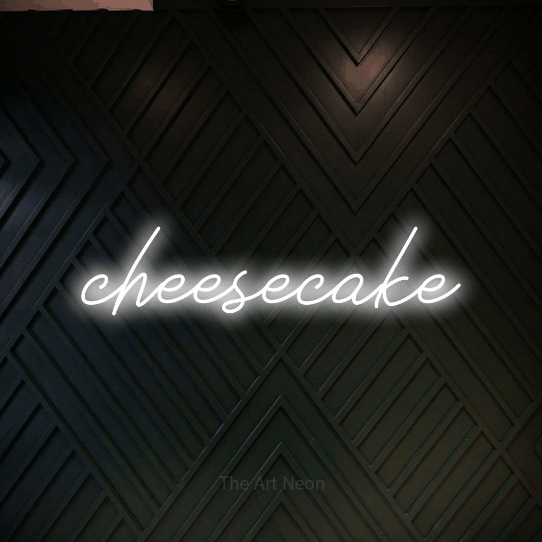 LED neon sign reading “cheesecake”, arranged in a single line.