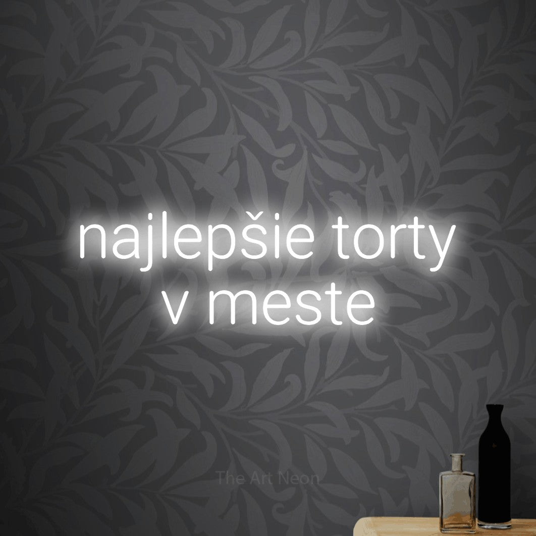LED neon sign reading “najlepšie torty v meste”, arranged in two lines.