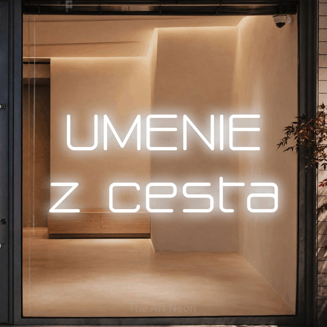 LED neon sign reading “UMENIE z cesta”, arranged in two lines.