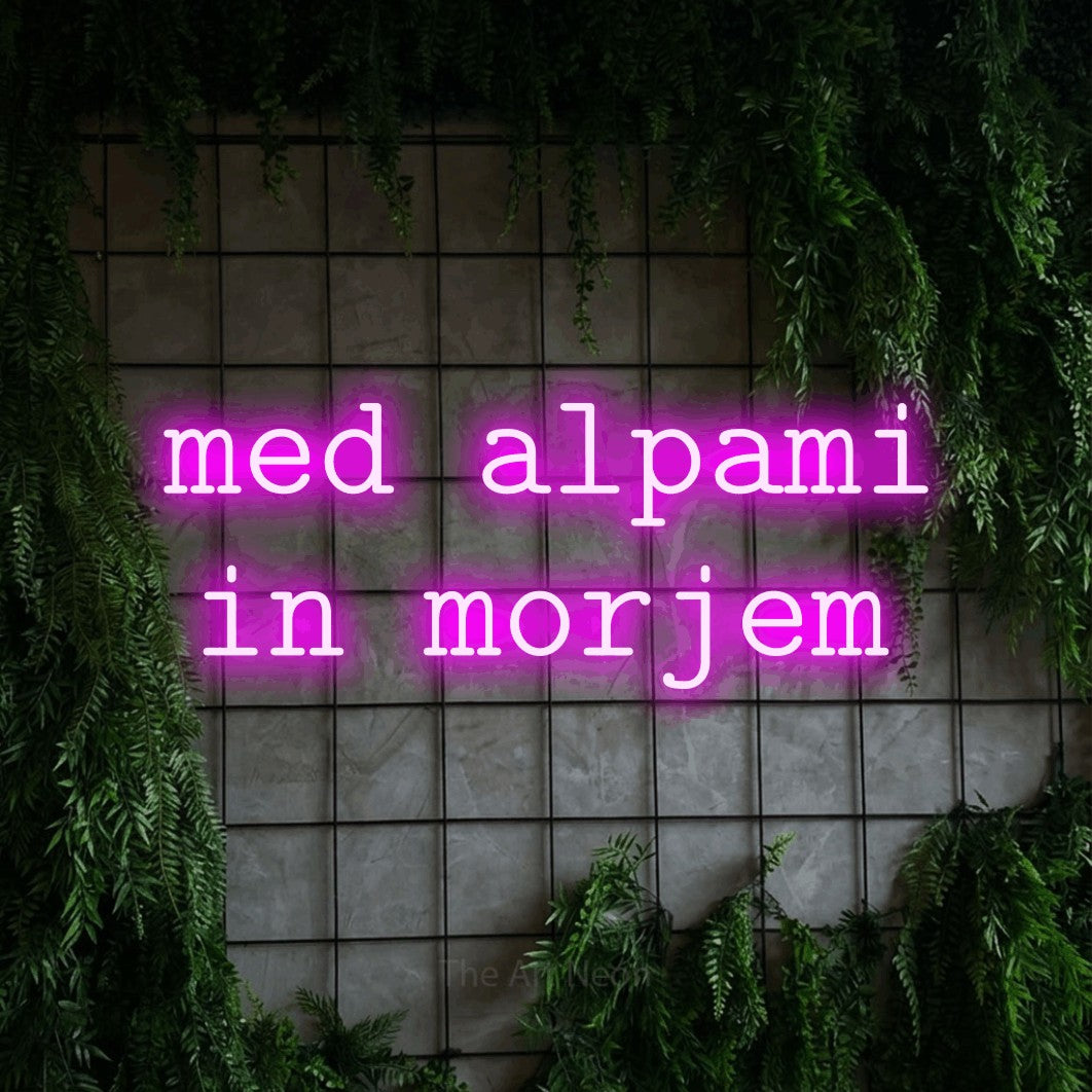 LED neon sign reading “med alpami in morjem”, arranged in two lines.