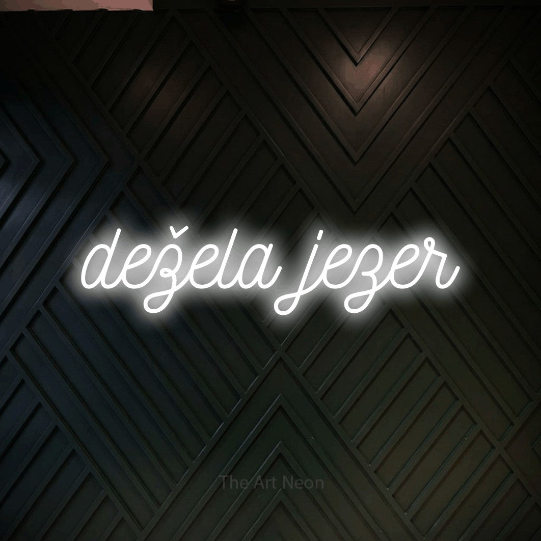 LED neon sign reading “dežela jezer”, arranged in a single line.