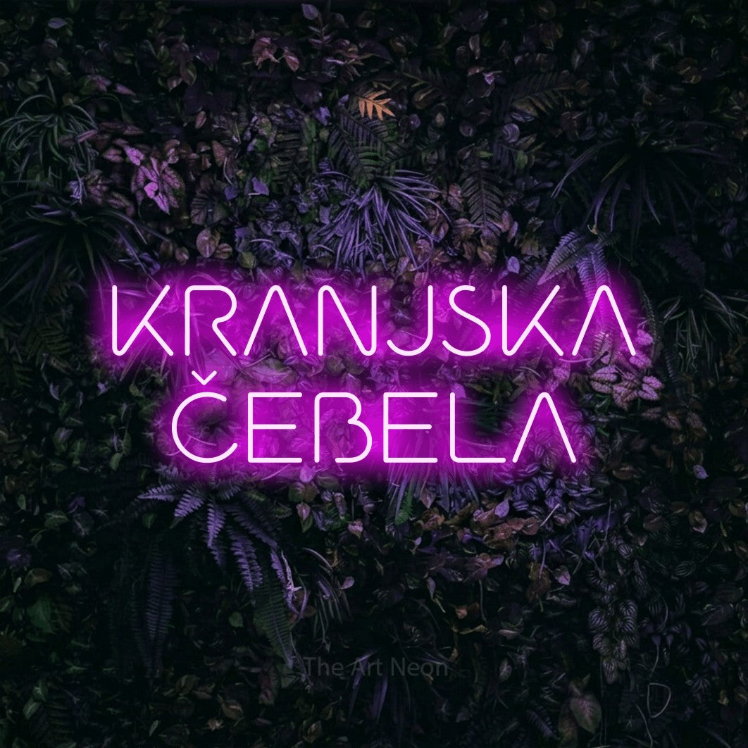LED neon sign reading “KRANJSKA ČEBELA”, arranged in two lines.