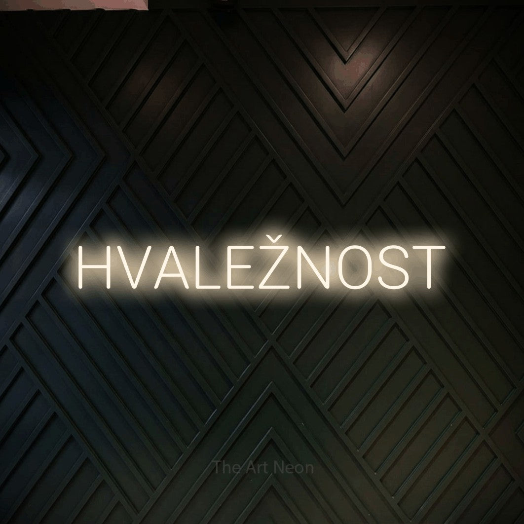 LED neon sign reading “HVALEŽNOST”, arranged in a single line.