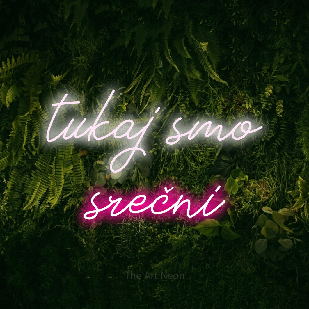 LED neon sign reading “tukaj smo srečni”, arranged in two lines.