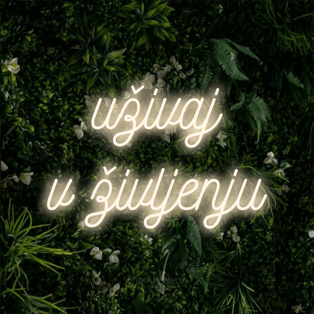 LED neon sign reading “uživaj v življenju”, arranged in two lines.