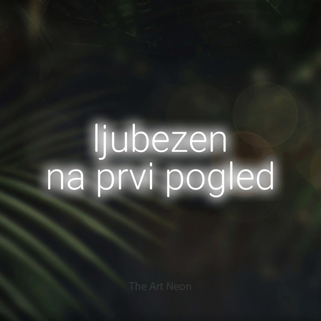 LED neon sign reading “ljubezen na prvi pogled”, arranged in two lines.