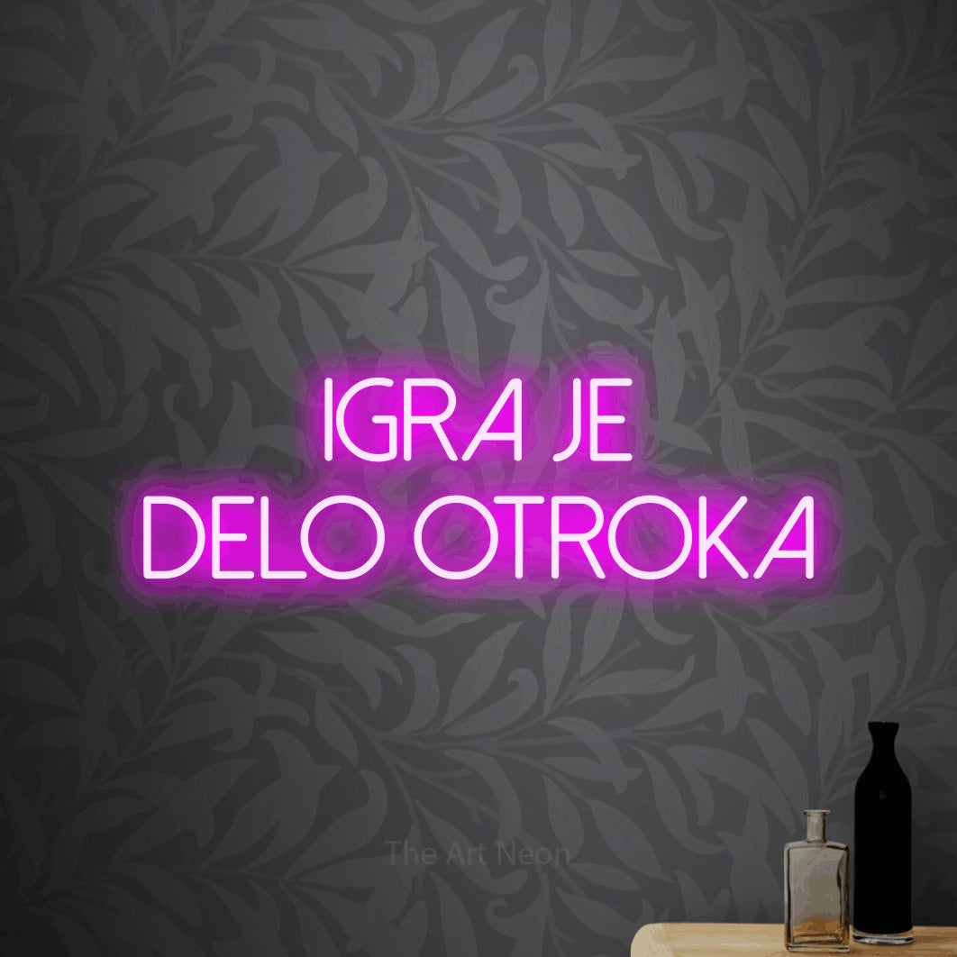 LED neon sign reading “IGRA JE DELO OTROKA”, arranged in two lines.