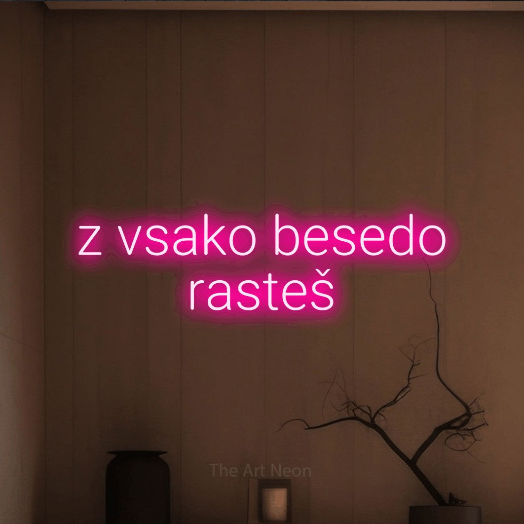LED neon sign reading “z vsako besedo rasteš”, arranged in two lines.