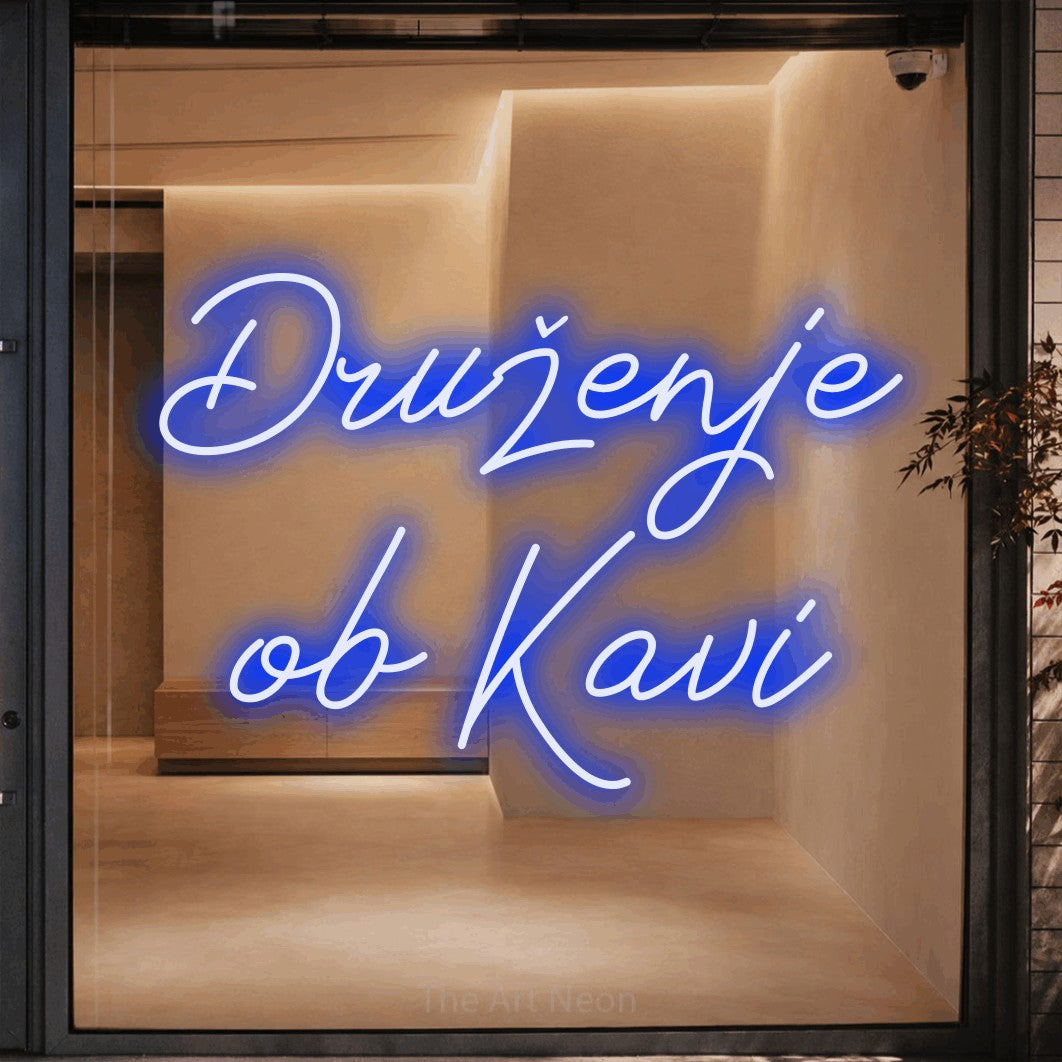 LED neon sign reading “Druženje ob Kavi”, arranged in two lines.