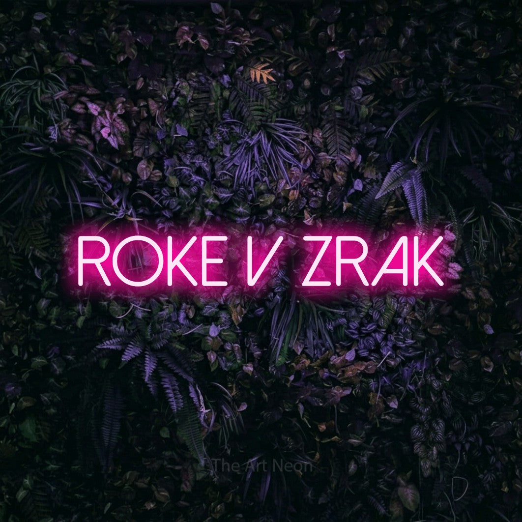 LED neon sign reading “ROKE v Zrak”, arranged in a single line.
