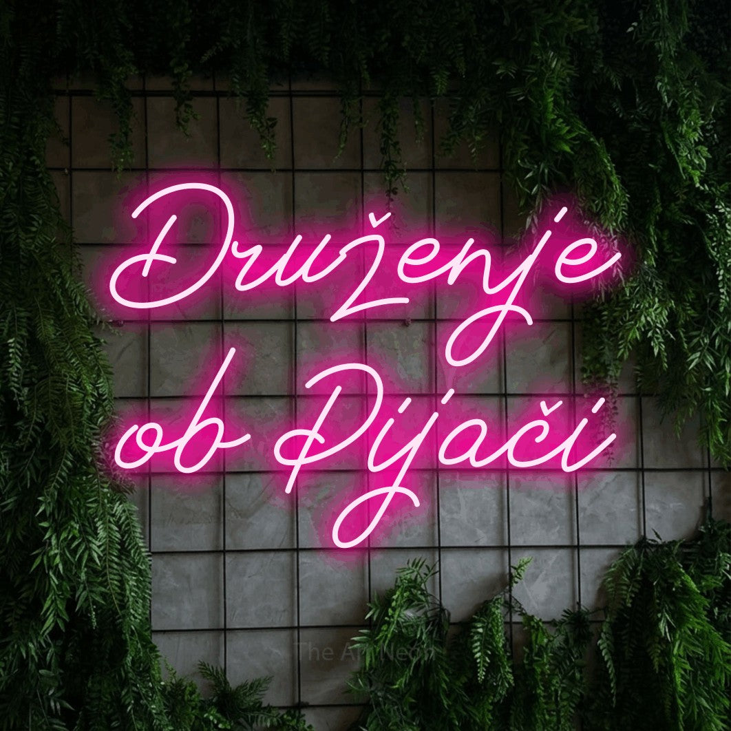 LED neon sign reading “Druženje ob Pijači”, arranged in two lines.