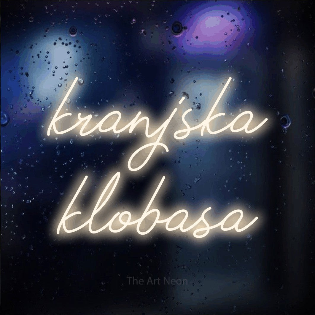 LED neon sign reading “kranjska klobasa”, arranged in two lines.