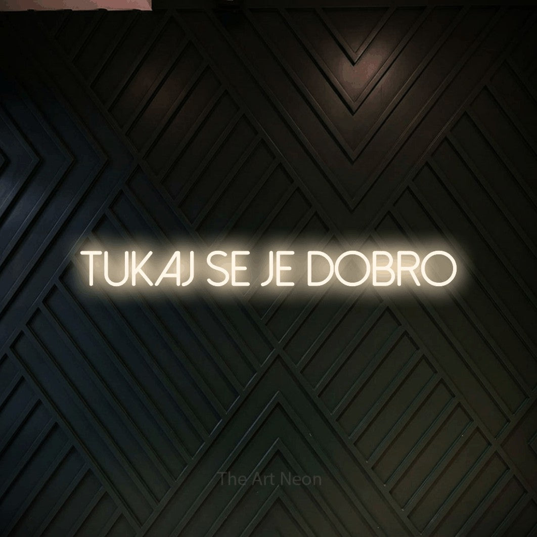 LED neon sign reading “tukaj se je dobro”, arranged in a single line.