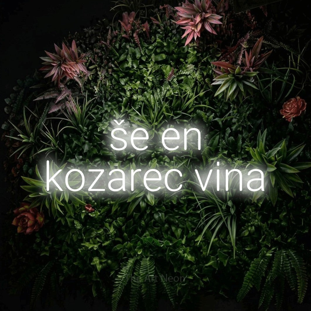 LED neon sign reading “še en kozarec vina”, arranged in two lines.