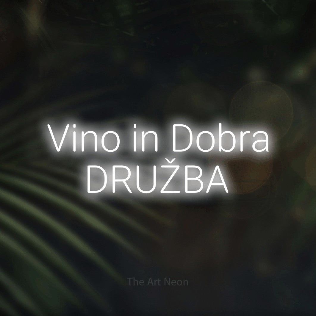 LED neon sign reading “Vino in Dobra DRUŽBA”, arranged in two lines.