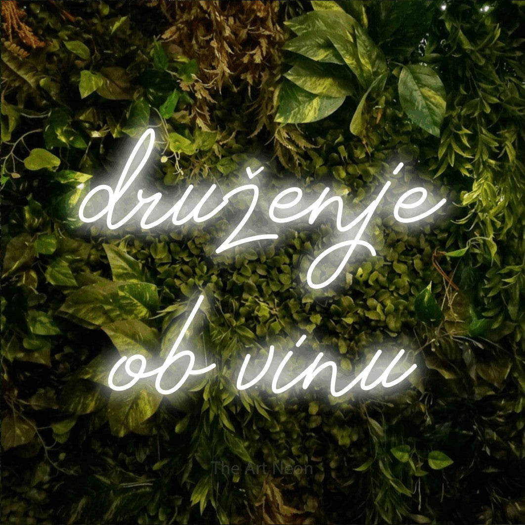 LED neon sign reading “druženje ob vinu”, arranged in two lines.