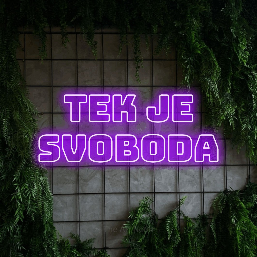 LED neon sign reading “tek je svoboda”, arranged in two lines.