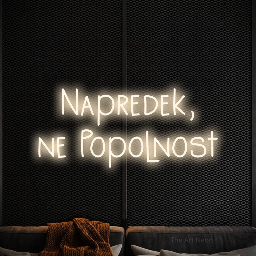 LED neon sign reading “Napredek, ne Popolnost”, arranged in two lines.