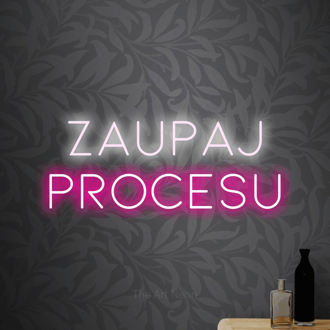 LED neon sign reading “zaupaj procesu”, arranged in two lines.