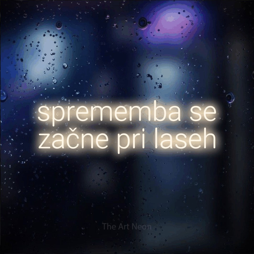LED neon sign reading “sprememba se začne pri laseh”, arranged in two lines.
