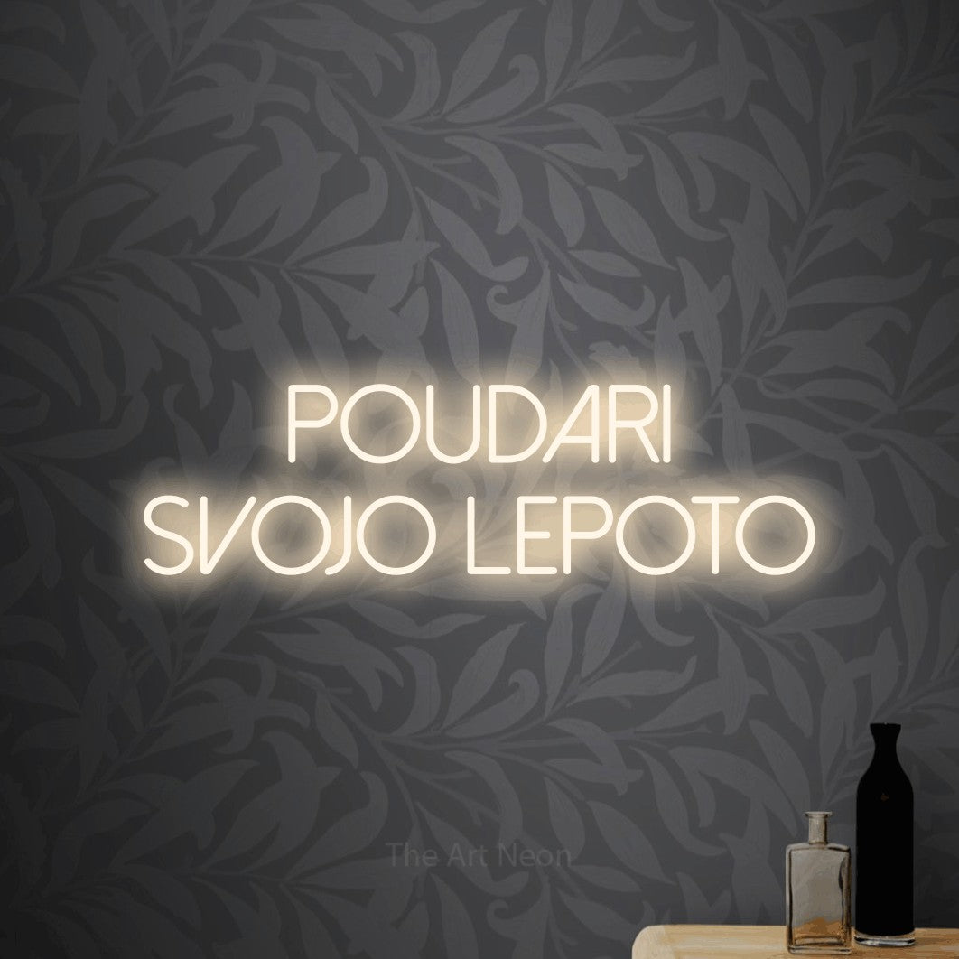 LED neon sign reading “poudari svojo lepoto”, arranged in two lines.
