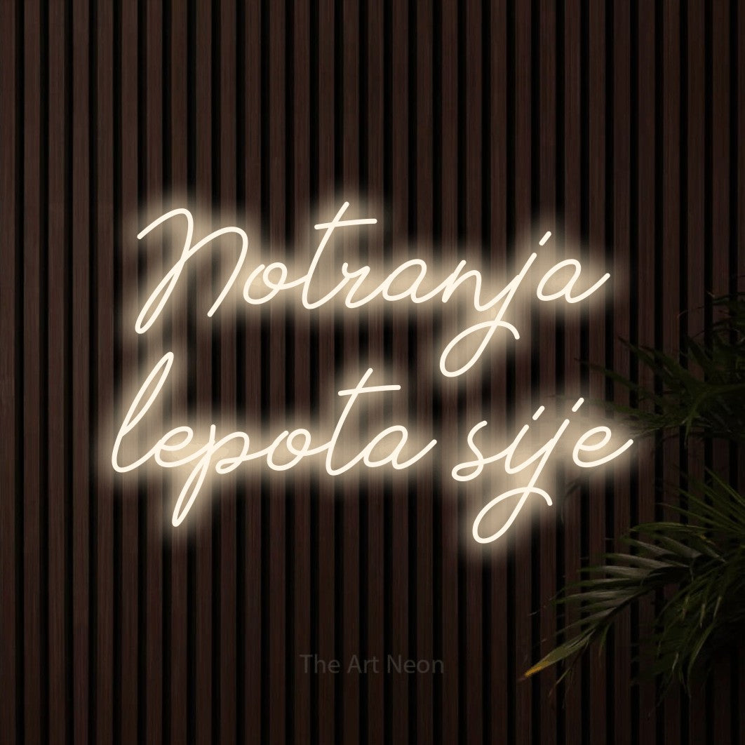 LED neon sign reading “Notranja lepota sije”, arranged in two lines.