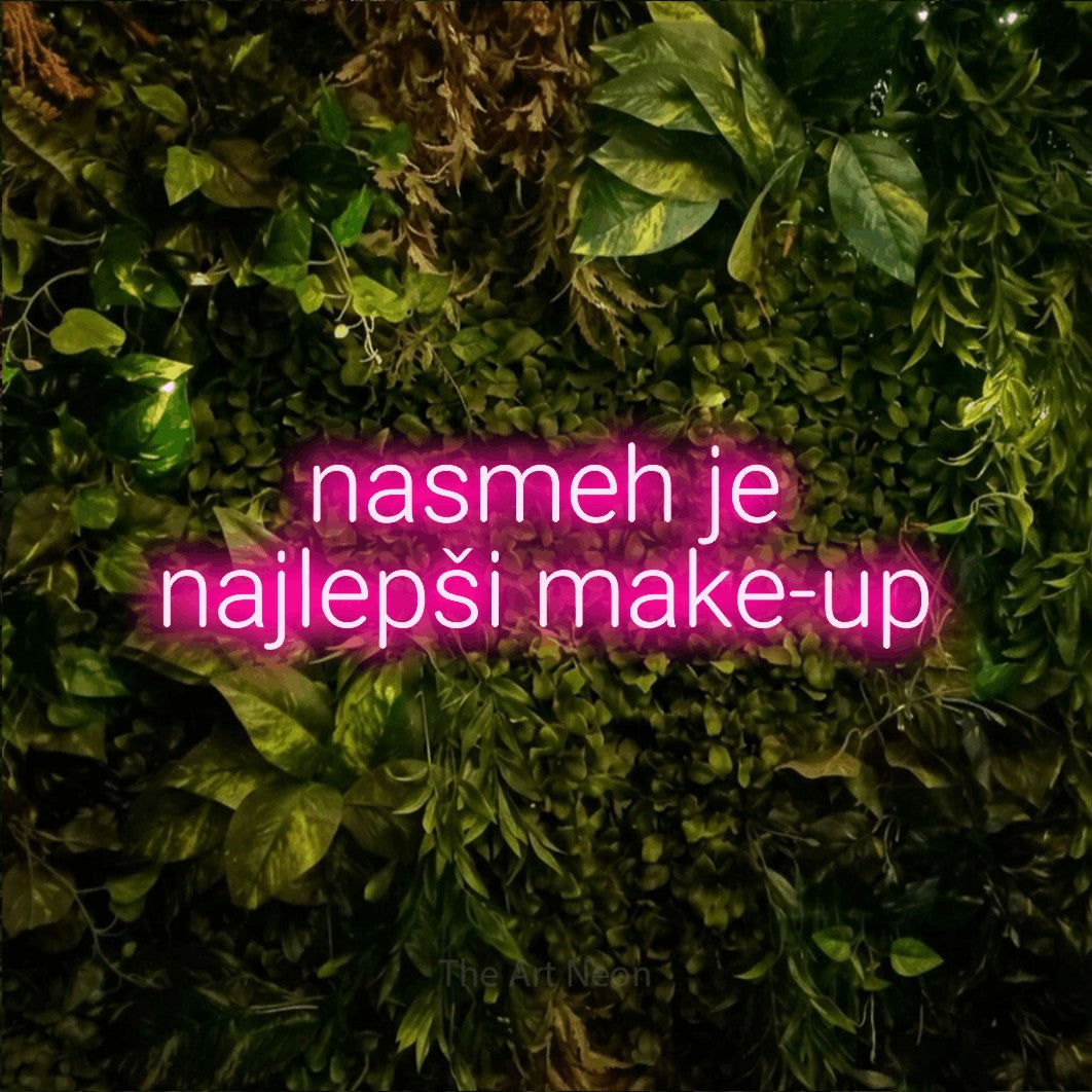 LED neon sign reading “nasmeh je najlepši make-up”, arranged in two lines.